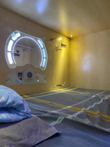 una camera ospedaliera con un letto e uno specchio di Sleep Cubee Hostel a Hong Kong