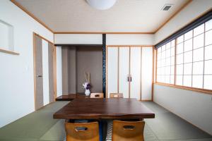 comedor con mesa de madera y sillas en THE VILLA FURANO【Wide Horizon】 en Furano