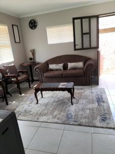 uma sala de estar com um sofá e uma mesa de centro em The Terrace Guest House em Roodepoort