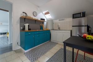 une cuisine avec des armoires bleues et une table noire dans l'établissement N° 8 - Metz City Centre - Travail & Loisirs, à Metz