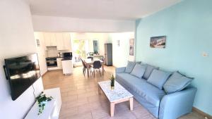 - un salon avec un canapé bleu et une table dans l'établissement Dream Escape Apt 1 - 6 min walk to Kastella Beach!, à Larnaka