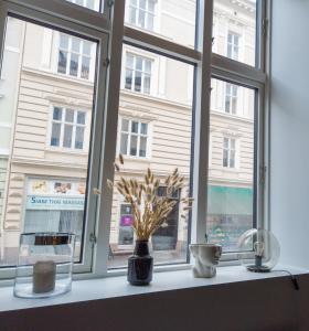 a window with vases and flowers on a window sill at Central and modern apartment in Oslo in Oslo
