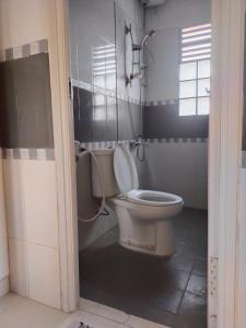 a bathroom with a toilet with the lid up at Wildan Homestay in Mangun