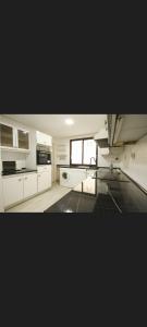 a large kitchen with white cabinets and a window at Centro Catedral Carrera 27, 1 plaza de aparcamiento y NETFLIX gratis in Jaén