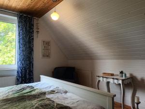 a bedroom with a bed and a table and a window at De Dackluuk in Wittmund