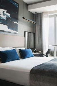 a bedroom with a large bed with blue pillows at 1 Bedroom Luxury Apartment in Luxury Hotel & Apartments in Sandton Central in Johannesburg