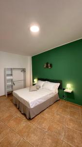 a bedroom with a large bed with a green wall at Dimora la Motta in Modugno