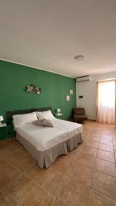 1 dormitorio con cama y pared verde en Dimora la Motta, en Modugno