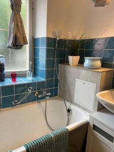 a bathroom with a bath tub and a sink at Froilein Sophie - Wlan, Küche, TV in Malterdingen