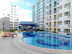 a large swimming pool in front of a building at Spacious 36sqm Studio with 65" TV Netflix Karaoke and Pool Access Near Airport and Samal Ferry in Dasag