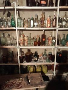 une étagère remplie de nombreuses bouteilles en verre dans l'établissement Riveside, à Martvili