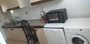y cocina con microondas y lavadora. en Habitación individual en Alicante