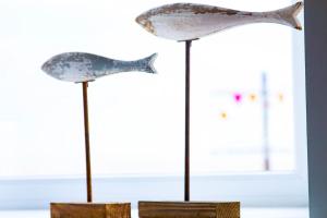 two fish ornaments sitting on sticks in front of a window at Seafront Apartment with Stunning Views in Cleethorpes