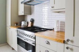 a kitchen with white cabinets and a stove top oven at Seafront Apartment with Stunning Views in Cleethorpes