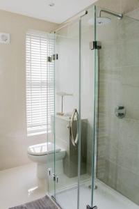a bathroom with a toilet and a glass shower at Seafront Apartment with Stunning Views in Cleethorpes