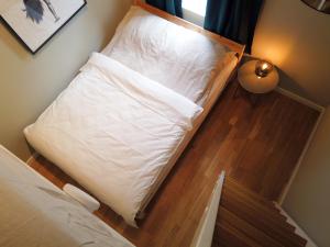 łóżko w pokoju z białą poduszką w obiekcie Central and modern apartment in Oslo w Oslo