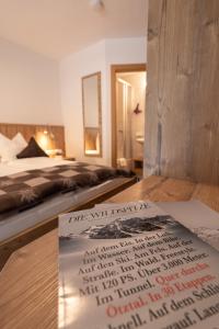 a sign on a table in a bedroom with a bed at Senner Appartements in Umhausen