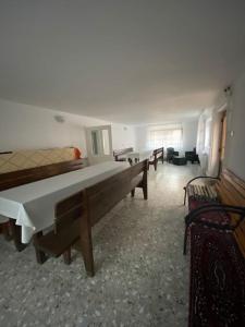 a room with tables and benches in a building at Casă de vacanță în zona montană in Sântimbru-Băi