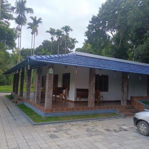 una casa con porche con techo azul en PADAVAYAL GREENS, en Attappādi