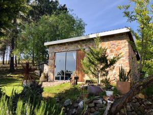 a stone house with a large window in a garden at Das Steinhaus in Napier