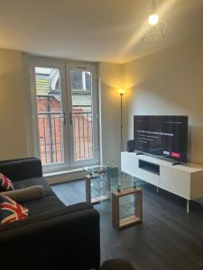 a living room with a couch and a flat screen tv at Best hotel Leicester city in Leicester