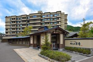 een groot appartementencomplex voor een parkeerplaats bij Jozankei Onsen Yurakusoan in Jozankei