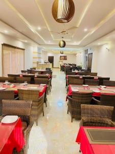 um restaurante com mesas e cadeiras com guardanapos vermelhos em Maria Hotel and Resorts em Kalām