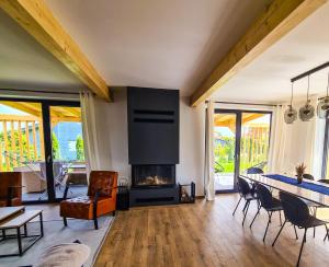 a living room with a fireplace and a table and chairs at Villa HyggeBaltic in Zastań