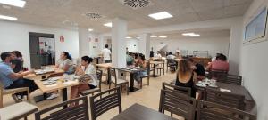 een groep mensen die aan tafel zitten in een restaurant bij Hotel Costa Brava in Roses