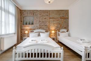 ミエンジズドロイェにあるDwie Wieżeのレンガの壁、ベッド2台が備わるベッドルーム1室が備わります。