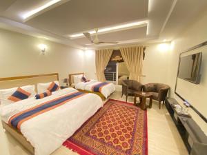 um quarto de hotel com duas camas e uma televisão de ecrã plano em Maria Hotel and Resorts em Kalām
