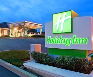 a hiltoniny inn sign in front of a parking lot at Holiday Inn Redding by IHG in Redding