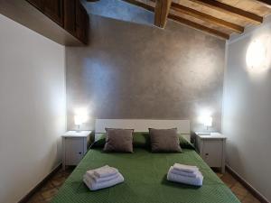 a bedroom with a green bed with two night stands at Casa Vacanze Porta di Valle in Bagnoregio