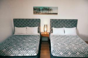 a hotel room with two beds and a table with a lamp at Maria Aliyah Events and Resort in Santa Cruz