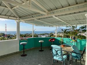 a patio with a table and chairs and a view of the ocean at Panorama Villa in La Gaulette
