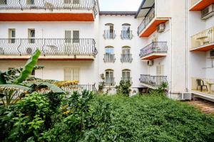 萊托揚尼的住宿－達佩普酒店，公寓大楼前设有阳台和灌木丛