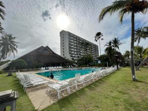 a swimming pool with white chairs and a building at The Regency Tanjung Tuan Beach Resort Port Dickson in Port Dickson +11 photos