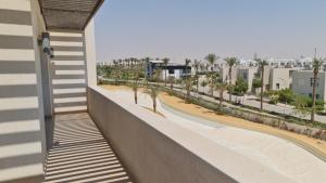 un balcón de un edificio con palmeras y edificios en Azha ain sokhna luxury chalet - families only - 155sqm special weekly monthly rates, en Ain Sokhna