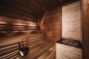 an empty wooden sauna with a bucket in it at Hotel Cavallino D'Oro Bed&Breakfast in Castelrotto +145 photos