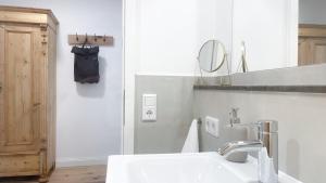 uma casa de banho branca com um lavatório e um espelho em Apartments am Dom em Naumburg