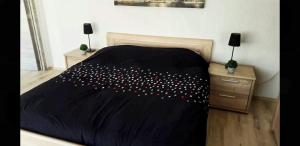 um quarto com uma cama com um edredão preto em chouette appartement 2 chambres em Seraing
