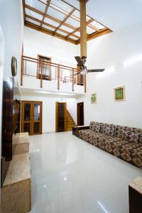 a living room with a couch and a ceiling fan at The Royal Villa in Panchgani