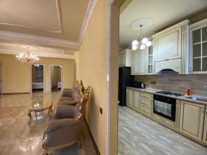 a kitchen with a row of chairs in a room at AL SHEIKH 5 BEDROOM LUXURY APARTMENT 1 in Yerevan