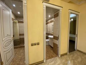 a bathroom with a shower and a toilet and a mirror at AL SHEIKH 5 BEDROOM LUXURY APARTMENT 1 in Yerevan