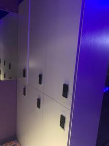 a locker room with purple lights on a wall at Sleep Cubee Hostel in Hong Kong