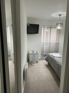 a bedroom with a bed and a flat screen tv at Heronsgate GH014 in Belvedere