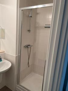 a shower with a glass door next to a sink at Heronsgate GH014 in Belvedere