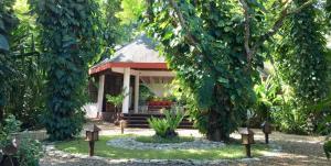 a small gazebo in a garden with trees at Mandala Spa & Resort Villas in Boracay