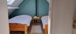 zwei Einzelbetten in einem Zimmer mit Fenster in der Unterkunft Polderrust in De Haan