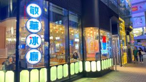 a store with signs in the window of a street at Sleep Cubee Hostel in Hong Kong